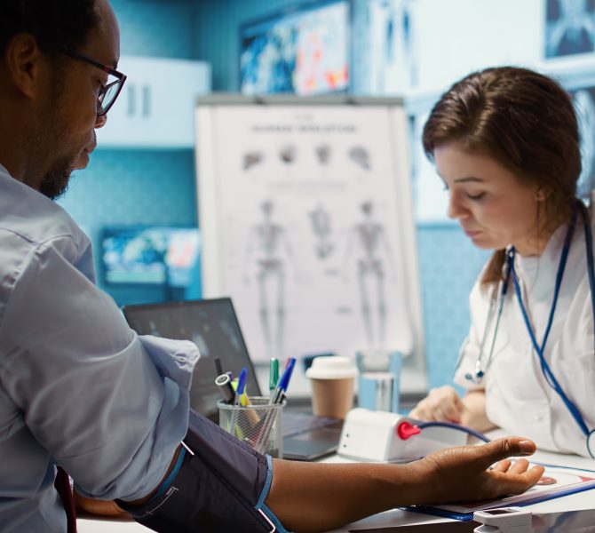 Female medic measuring blood pressure and pulse for a patient